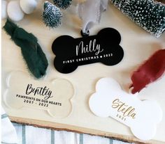 personalized dog tags are displayed on a wooden board with christmas trees and snowflakes