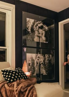 a bedroom with black walls and pictures on the wall