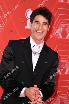 an image of a man in a suit posing for the camera on the red carpet