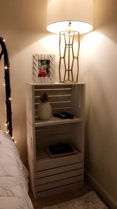 a bedroom with a bed, lamp and bookcase in the corner next to it