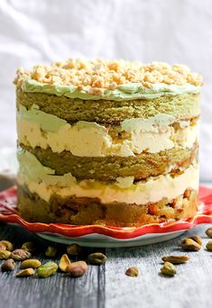 a layered cake with pistachios and frosting