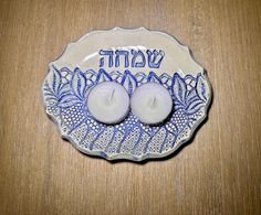 two lit candles sitting on top of a blue and white plate