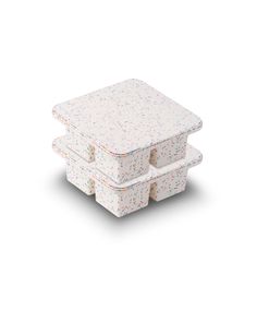 three white boxes with sprinkles on the top and bottom, stacked together