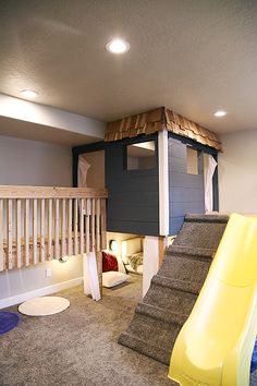 a room with a slide, stairs and carpeted flooring in front of it