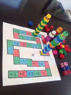 a table topped with legos and toys on top of a white paper sheet covered in colored blocks