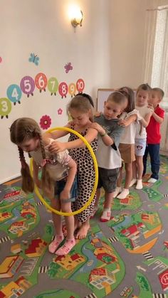 children are playing with hoop toys on the floor in a playroom at an elementary school