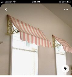 two windows with red and white striped awnings