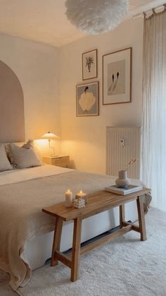 a bed room with a neatly made bed and pictures on the wall