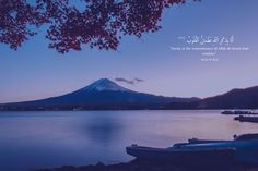 two boats are sitting on the shore with a mountain in the background and an arabic quote