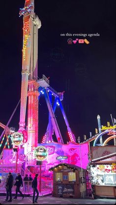 people are walking around an amusement park at night