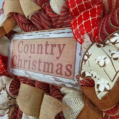 a red and white wreath with the words country christmas written on it, surrounded by burlap