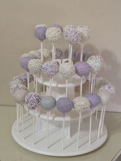 cake pops are stacked on top of each other with purple and white frosted toppings