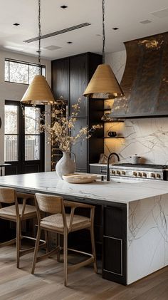 a kitchen with an island and two pendant lights hanging from it's ceiling over the stove