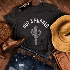 Cute Not A Hugger Cactus shirt with a country western vibe, is a great gift for the woman in your life that loves her own personal space! ❤️Love the design and want it in a sweatshirt? We got you covered. Tap here:   SHORT SLEEVE TSHIRT FIT: ⚡️Tapered shoulder so it retains its shape even after washing. ⚡️crew neckline adds a timeless, classic touch and a neat appearance that is perfect for showcasing accessories like necklaces or scarves.  COMFORT / QUALITY / MATERIAL ⚡️Soft cotton & quality pr Not A Hugger, Cactus Gift, Cactus Shirt, Cactus Gifts, Aesthetic Gift, Western Aesthetic, Tshirt Women, Country Western, Funny Shirts