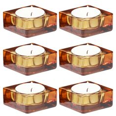 set of four square candle holders with candles in each one, gold and brown glass