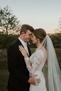 a bride and groom embracing each other in front of the sunset