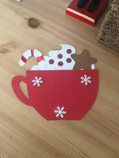 a paper cut out of a coffee cup with candy canes and snowflakes