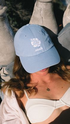 Crafted for both comfort and coastal cool, the Seak Hibiscus hat boasts a classic design that adds a touch of retro elegance to your look. Whether you're catching rays or simply strolling along the shoreline, this hat is your go-to for effortless beachside flair. * 100% chino cotton twill * Unstructured, 6-panel, low-profile * 6 embroidered eyelets * Adjustable strap with antique buckle This product is made especially for you as soon as you place an order, which is why it takes us a bit longer t Adjustable Beach Baseball Cap With Embroidered Logo, Beach Trucker Hat With Embroidered Logo And Curved Brim, Trucker Hat With Embroidered Logo For Beach, Cotton Trucker Hat For Vacation, Cotton Beach Baseball Cap, Casual Beach Hats With Embroidered Logo, Casual Beach Hat With Embroidered Logo, Casual Embroidered Baseball Cap For Beach, Cotton Baseball Cap For Beach