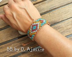 Wrap SuperDuos Picasso leather strap. Handmade bracelet boho chic style. Cuff Picasso Southwest style. Model BB by D. This Bracelet consists of Superduo glass beads, woven with C-Lon thread, on metallized bronze leather cords. It attaches with a loop, which it fits on a metal button Color Palette: Turquoise, yellow, burgundy, silver, bronze... The length of this Model is 16cm and adjusts to the wrist, up to 4 cm extra, using a leather buckle and a sliding knot. The buckle fits on a metal button. Handmade Bohemian Leather Bracelet For Beach, Handmade Adjustable Bohemian Leather Bracelet, Bohemian Handmade Leather Bracelet For Beach, Handmade Hippie Leather Bracelet, Handmade Trendy Brown Wrap Bracelet, Trendy Handmade Brown Wrap Bracelet, Handmade Turquoise Leather Bracelet, Bohemian Style, Multicolor Bohemian Leather Bracelet As Gift, Handmade Multicolor Bohemian Leather Bracelet