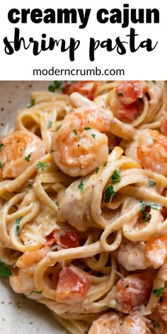 shrimp pasta with creamy cream sauce in a white bowl on a wooden table and text overlay that reads, super creamy cajun shrimp linguinne