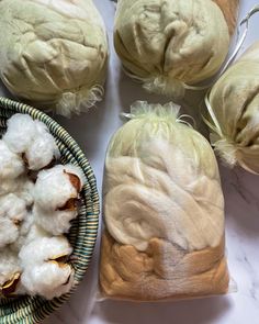 three baskets filled with cotton sitting on top of a white marble counter next to each other