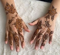 two hands with henna designs on them