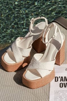 A summer spent with the D'Amelio Footwear Raela White Eyelet Embroidered Platform Ankle Strap Sandals is a summer spent in sensational style! These too-cute sandals start with a raffia-wrapped, 1.5"" toe platform that creates a square footbed, along with floral eyelet embroidered vamp straps that crisscross atop an open-toe upper. A supportive heel strap holds an adjustable ankle strap that secures with a white buckle, all above a matching raffia-wrapped, sky-high block heel. 5" raffia-wrapped h Closed Toe Lace-up Sandals For Beach Vacation, Synthetic Open Toe Lace-up Sandals For Vacation, Summer Block Heel Heels, White Closed Toe Sandals For Summer, White Wedge Sandals With Heel Strap For Summer, White Slingback Sandals With Round Toe For Summer, Synthetic Ankle Strap Lace-up Sandals For Beach, Summer Open Toe Synthetic Lace-up Sandals, Beach Closed Toe Lace-up Sandals