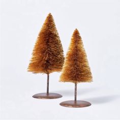 two small trees made out of straw on top of each other