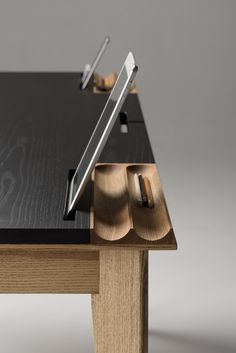 a wooden table with a black top and two silver objects on it's legs