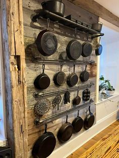 a kitchen wall with pots and pans hanging on it