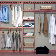 an organized closet with clothes hanging on wooden shelves