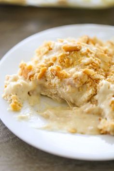 a white plate topped with mashed potatoes covered in gravy and crumbs