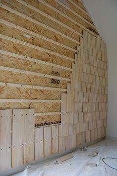 an unfinished room with wooden boards on the wall