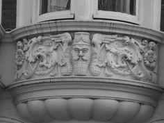 an old building with a decorative decoration on the front and side window sill in black and white