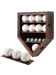 four baseballs in a wooden display case with six white balls on the bottom shelf