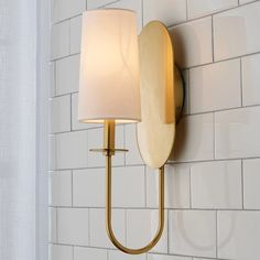 a wall light with a white shade on it in a bathroom or dining room area