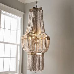 a chandelier hanging from the ceiling in a room with white walls and windows