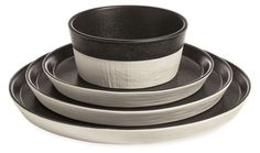 four black and white dishes stacked on top of each other, with one bowl in the middle