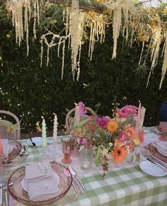 the table is set with flowers and candles on it for an outdoor dinner or party