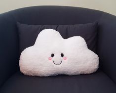 a white cloud pillow sitting on top of a black chair