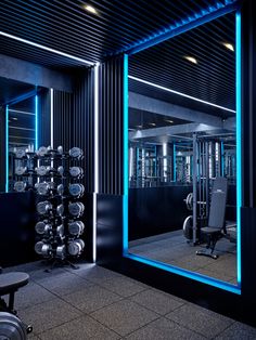 a gym with mirrors and exercise equipment in the background, lit up by blue lights