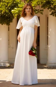 a woman in a white dress is posing for the camera with flowers on her bouquet