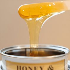 honey is being poured into a can