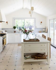 a kitchen with white cabinets and an island