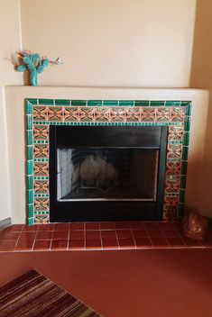 the fireplace is decorated with green and orange tiles