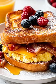 a breakfast sandwich with eggs, bacon and berries