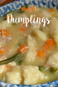 a bowl filled with dumplings and carrots on top of a blue and white plate