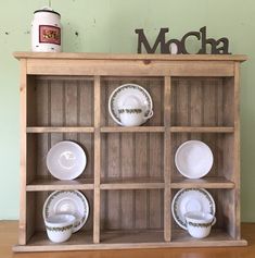 a wooden shelf with plates and cups on it