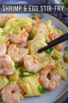 a white plate topped with shrimp and noodles next to chopsticks on a table