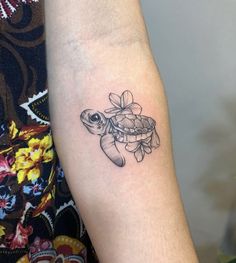 a small turtle tattoo on the arm